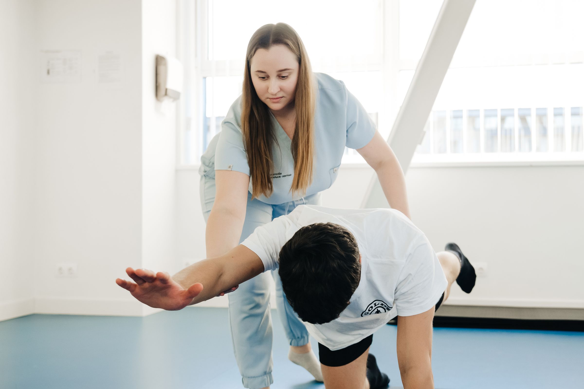 Physiotherapeutin unterstützt einen Patienten bei einer Übung in der Praxis